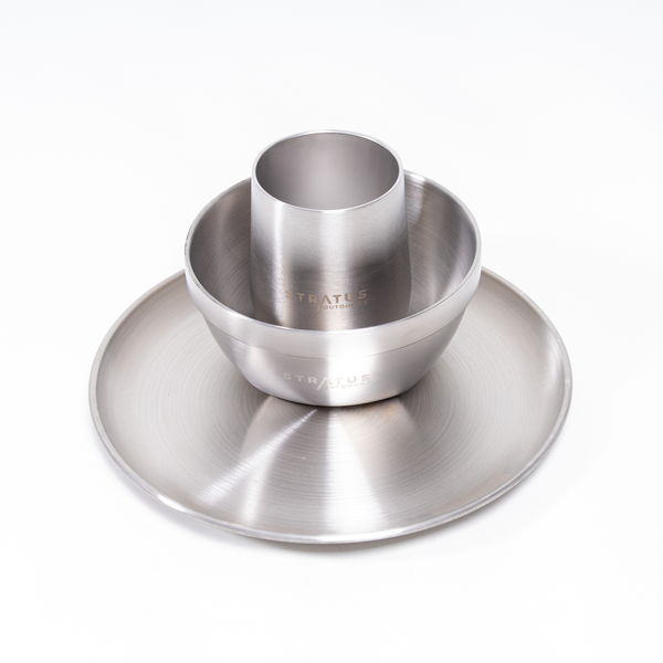 A stainless steel dinnerware set including a dinner plate, a double-walled bowl, and a double-walled cup, all displaying the Stratus brand name.