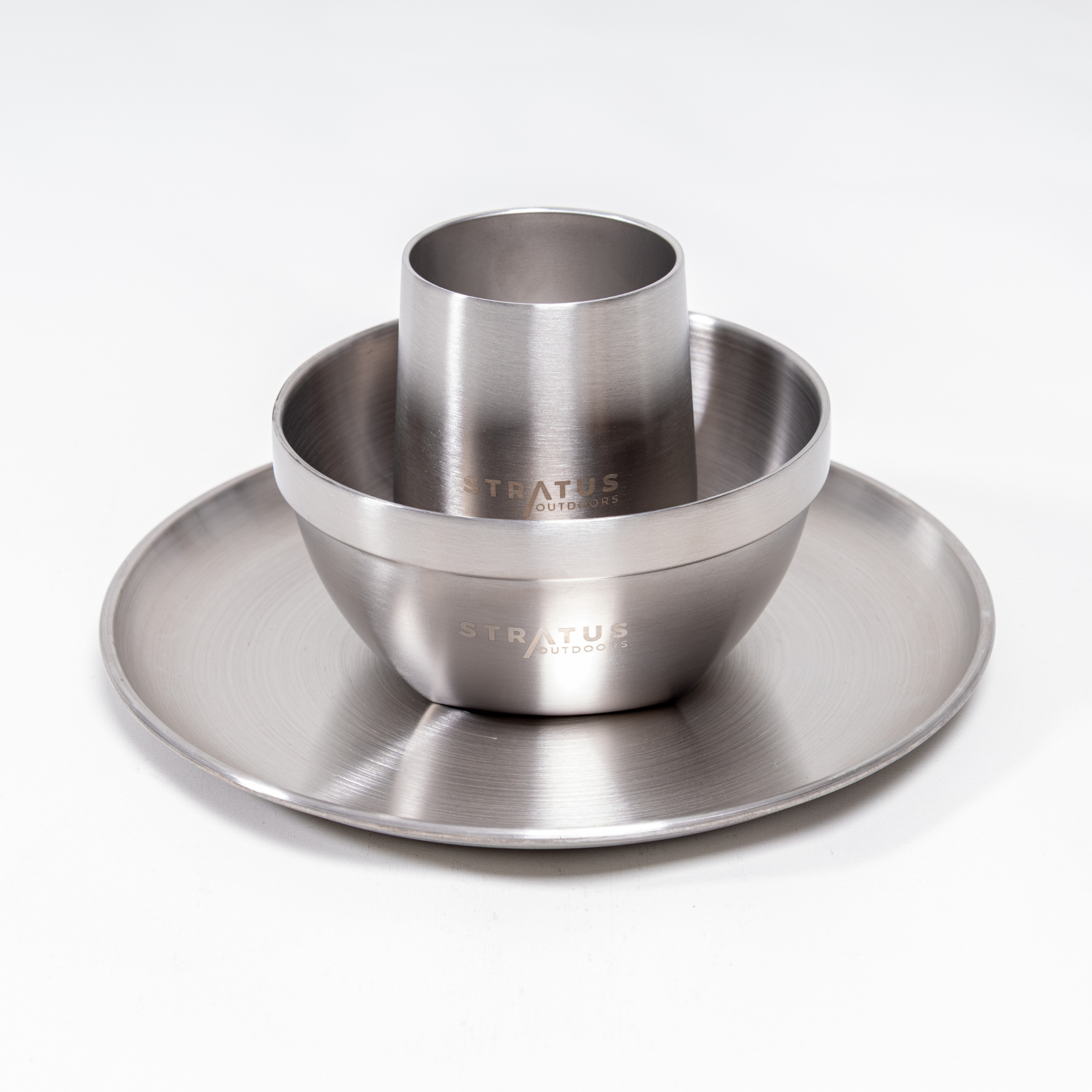 A stainless steel dinnerware set including a dinner plate, a double-walled bowl, and a double-walled cup, all displaying the Stratus brand name.