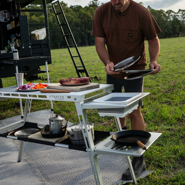 Sink Rack set up on grassy campsite, loaded with drying dishes and cups after an outdoor meal.